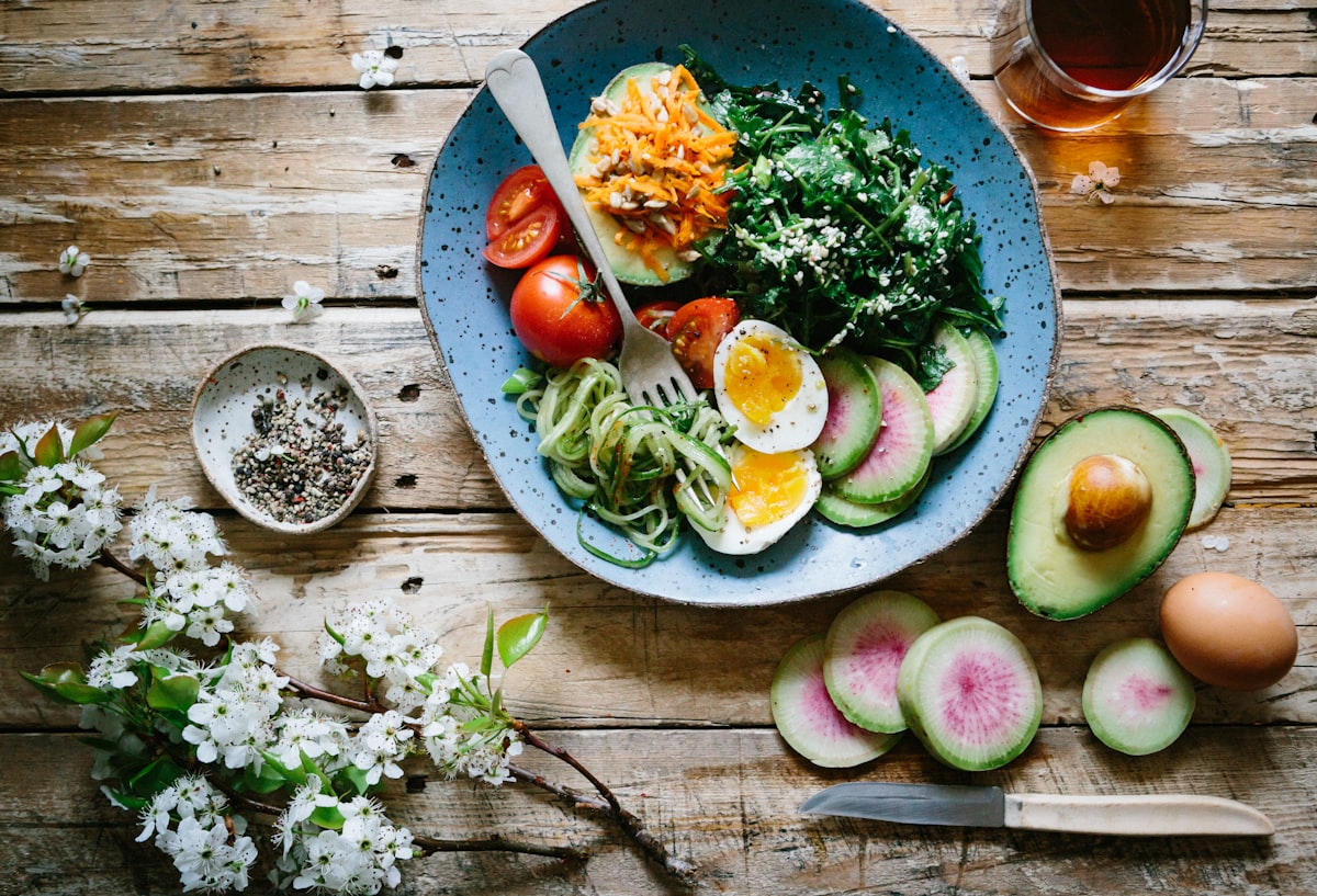Fresh meal bowl with avocado, tomatoes, chickpeas, sweet potato, and greens